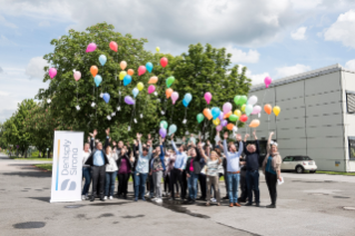 Dentsply Sirona employees cheering with ballons in front of Bensheim site