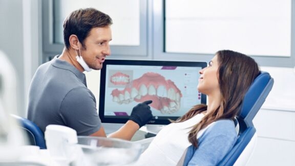 Dentist consulting patient, orthodontic treatment with CEREC Ortho