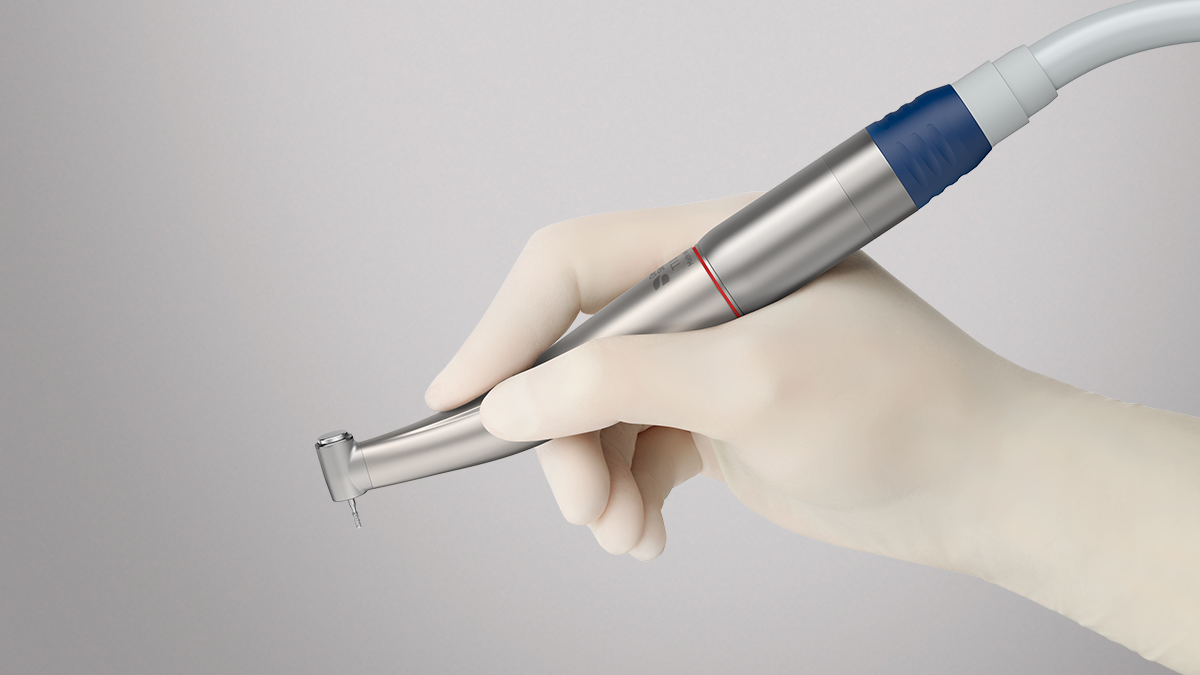 Hand hält ein dentales Handstück von Dentsply Sirona