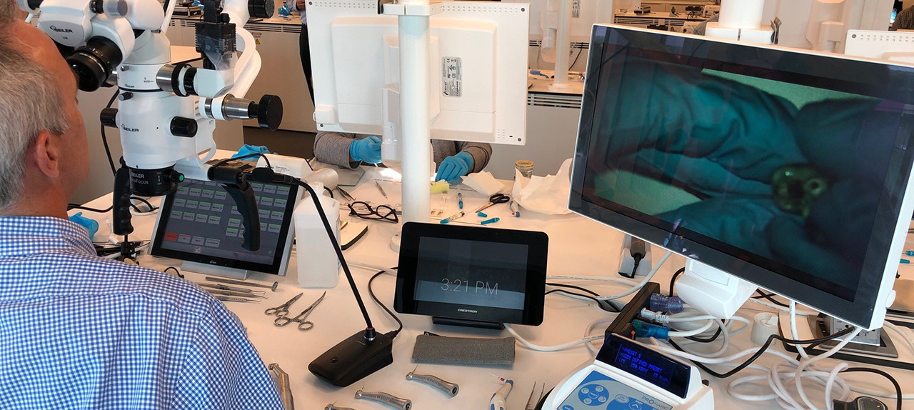 Endodontic training setup with microscope, monitors, and dental equipment for clinical education