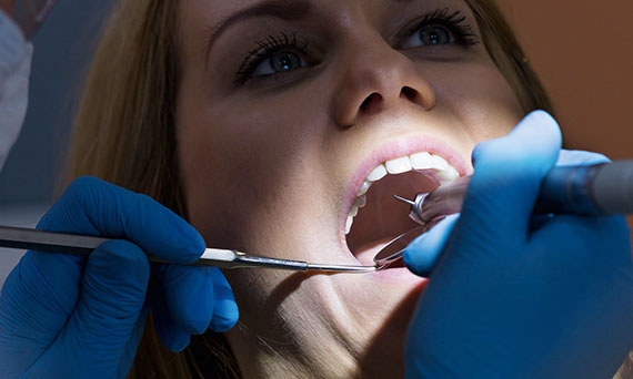 Dentist using dental light in exam