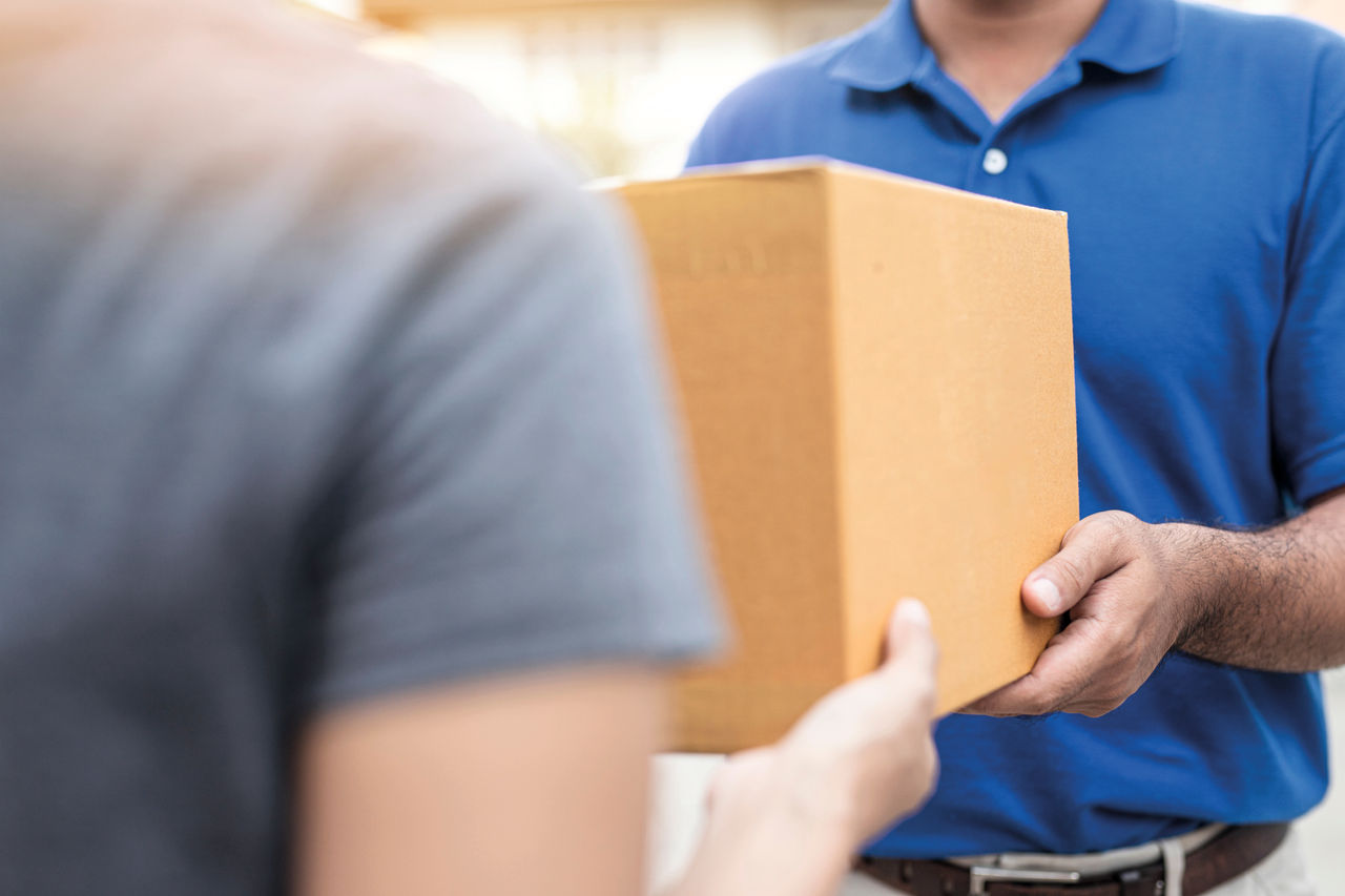 Woman hand accepting a delivery boxes of paper containers from deliveryman,Delivery concept.