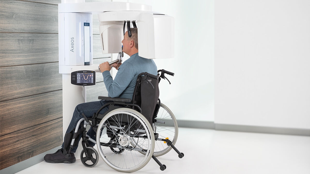 Vista lateral de un hombre discapacitado en silla de ruedas con la pieza de mordida oclusal en la boca.