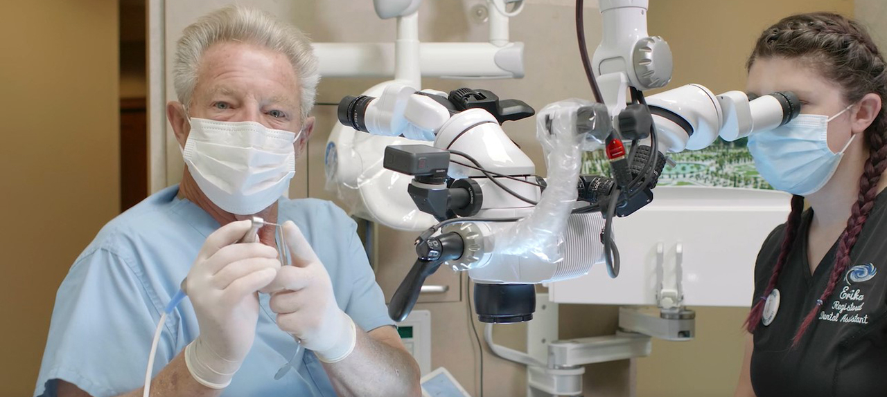 Dental professional using operating microscope for advanced endodontic treatment