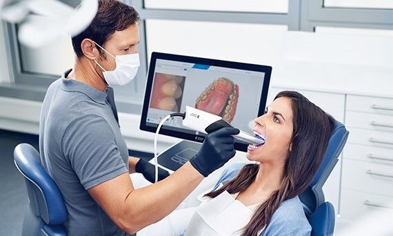 Dentist scanning female patient with Primescan