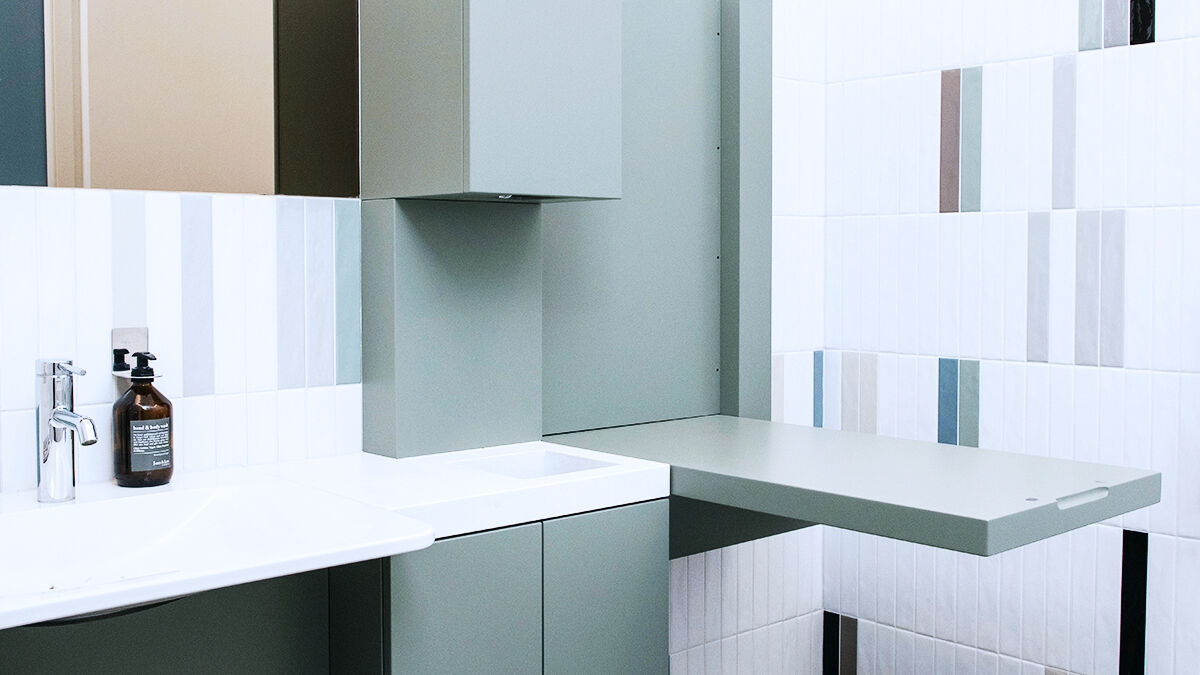 Bathroom with tiles in black, white and gray and minimalist design of the furniture in the dental practice Die Praxis Mitte in Berlin.