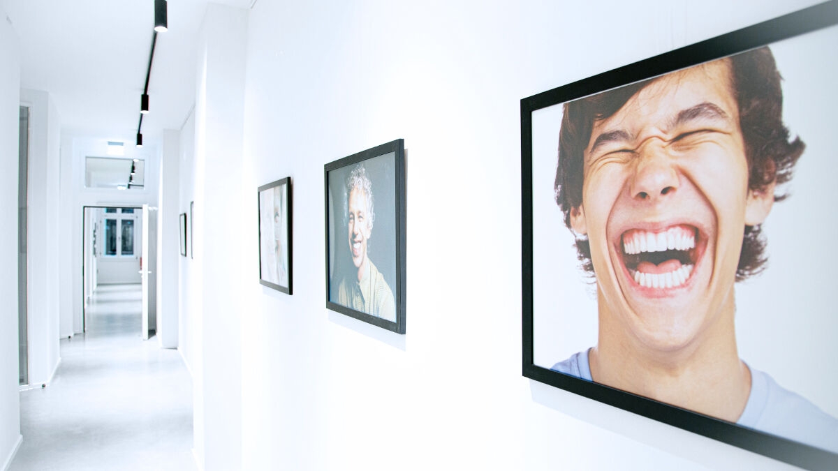 Hallway with photographs of laughing people.