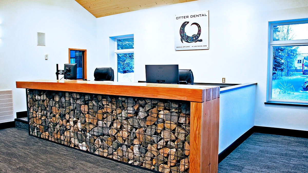Front desk made of wood on a gabion basket filled with local rocks.
