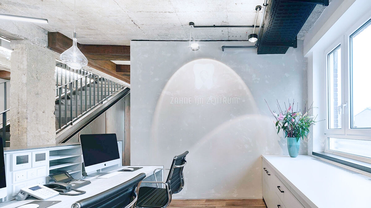 The lighting concept and minimalist design in the entrance area show off design elements such as the name of the dental practice Zähne im Zentrum in Münster.